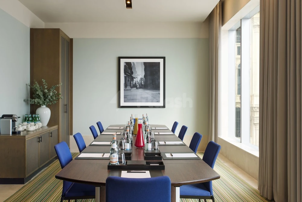 Meeting room at Assila, a Luxury Collection Hotel, Jeddah, with framed black-and-white photograph and blue chairs around