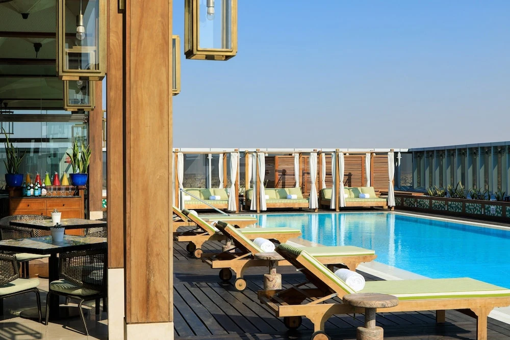 Rooftop pool at Assila, a Luxury Collection Hotel, Jeddah, with wooden loungers and glass lanterns