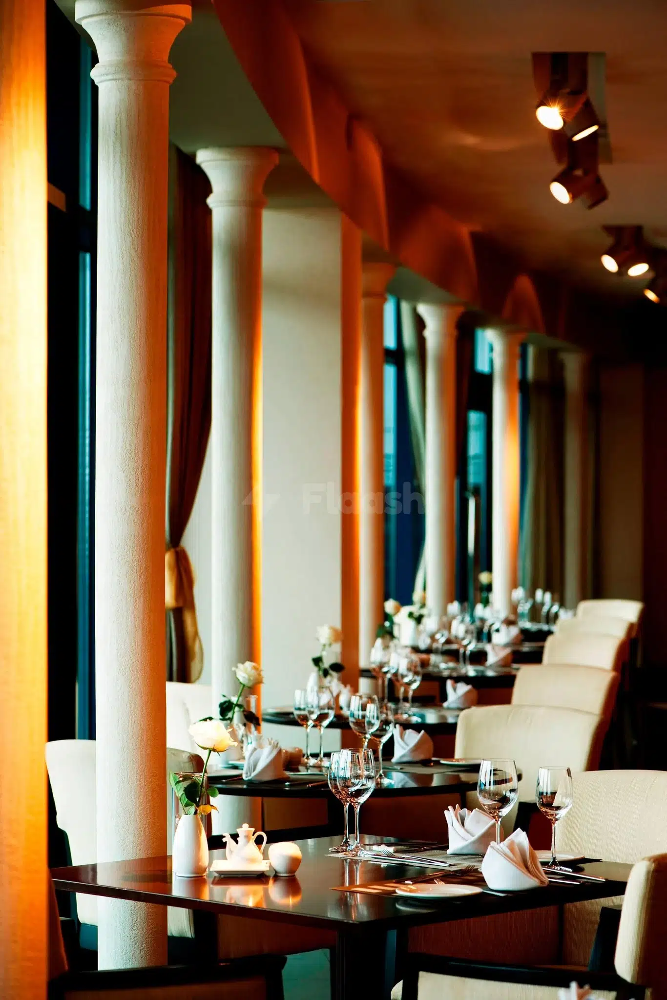Dining area at Le Méridien Al Aqah Beach Resort, Fujairah, with white columns and warm lighting