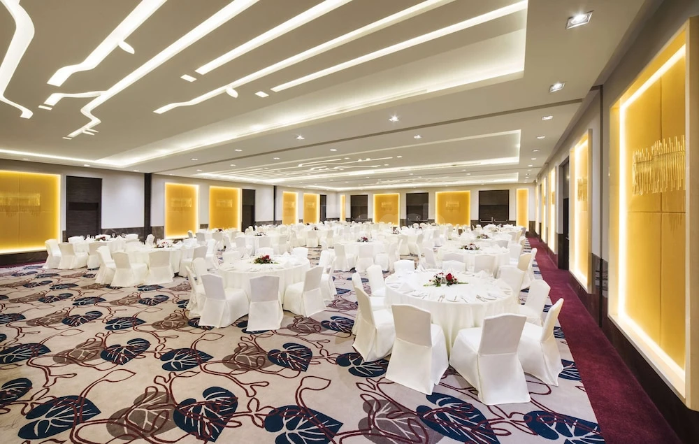 Banquet hall at Hilton Garden Inn Ras Al Khaimah, Ras Al Khaimah, with white-draped tables and illuminated gold