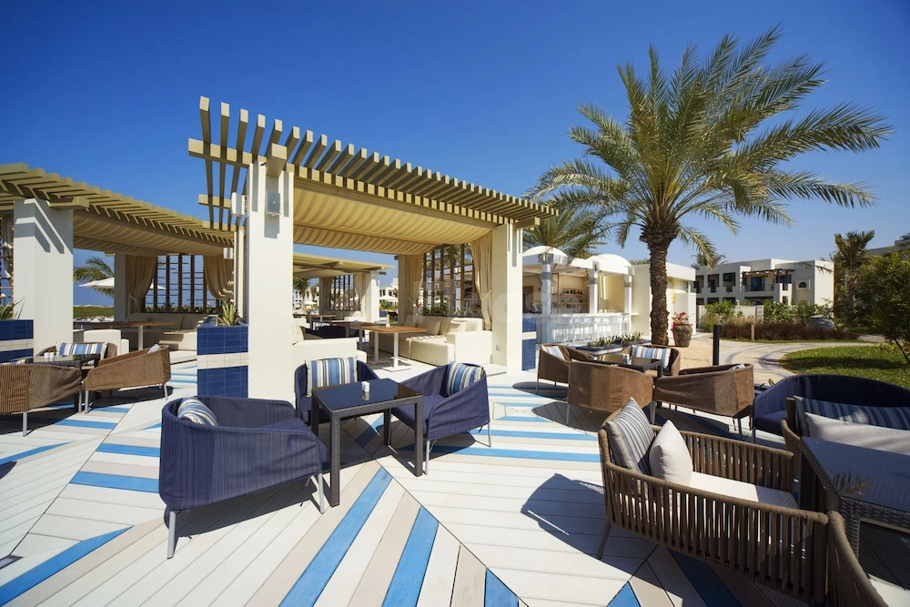 Outdoor lounge at Hilton Garden Inn Ras Al Khaimah, Ras Al Khaimah, with blue-striped decking and palm trees