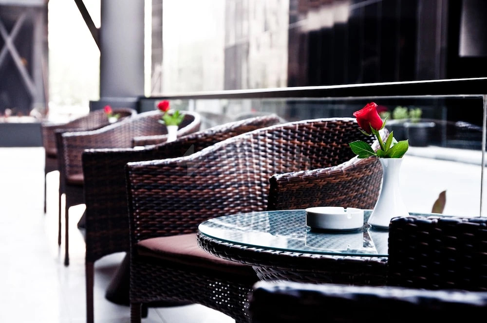 Outdoor seating area at Ramada Hotel & Suites by Wyndham Ajman, Ajman, with wicker chairs and red roses
