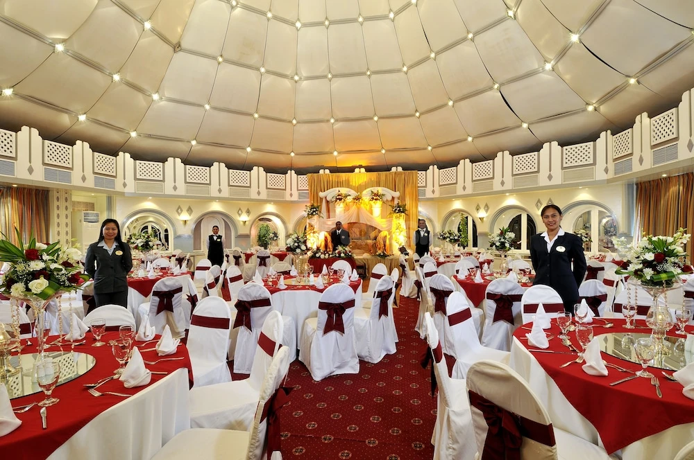 Luxury banquet hall at Marbella Resort, Sharjah, with red tablecloths and white chair covers