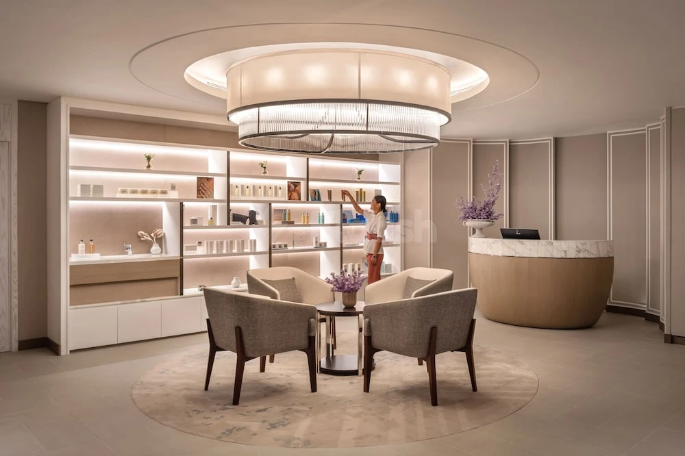 Lobby at Address Beach Resort Fujairah, Fujairah, featuring circular chandelier and built-in shelves with ambient lighting
