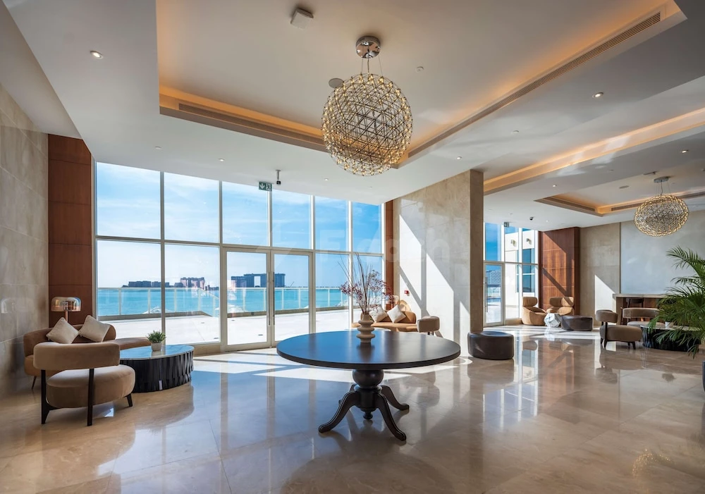 Lobby at Radisson Resort Ras Al Khaimah Marjan Island, Ras Al-Khaimah, with large glass walls and spherical chandeliers