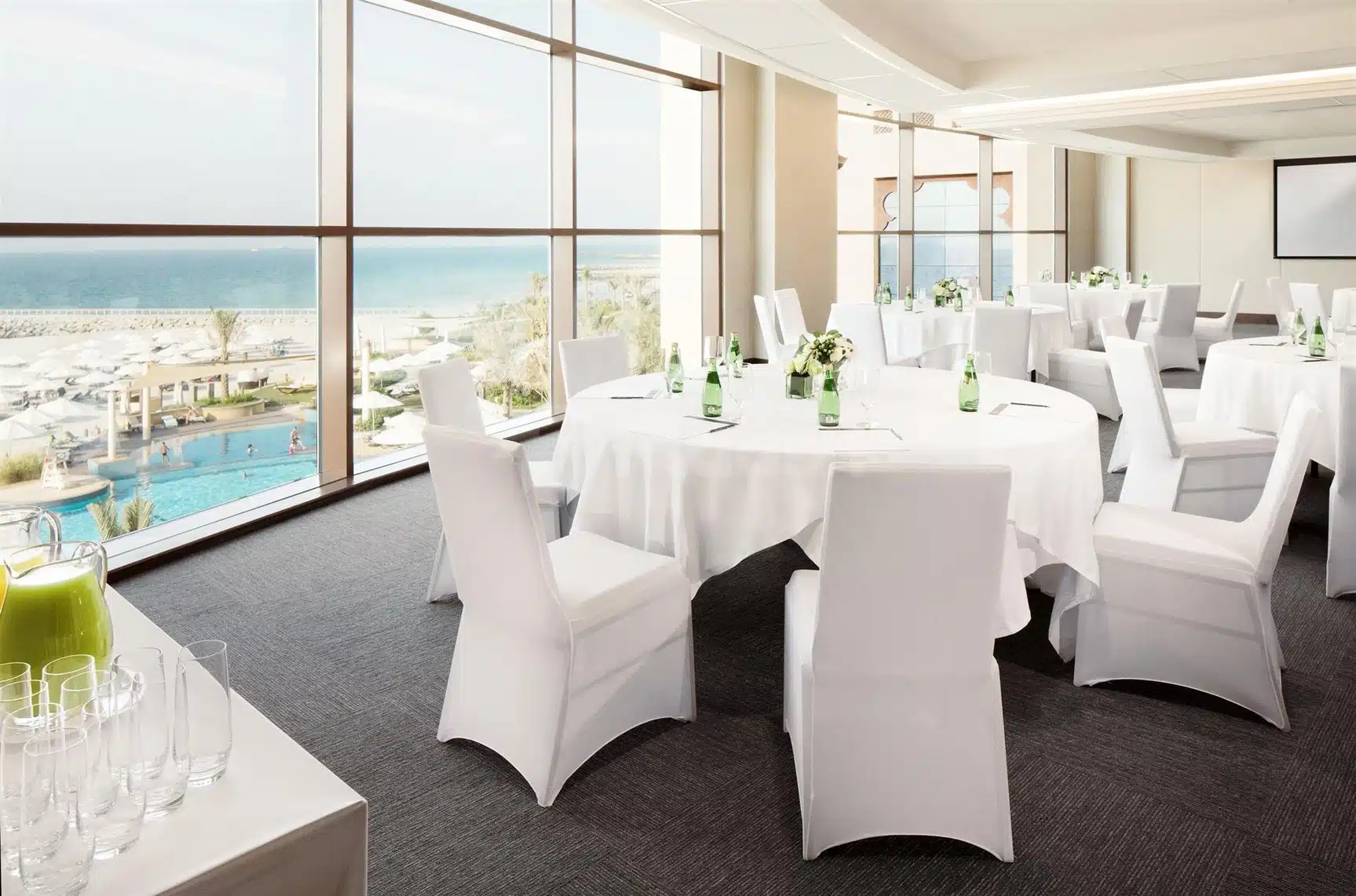 Banquet hall at Fairmont Ajman, Ajman, with ocean view through floor-to-ceiling windows and white-draped tables