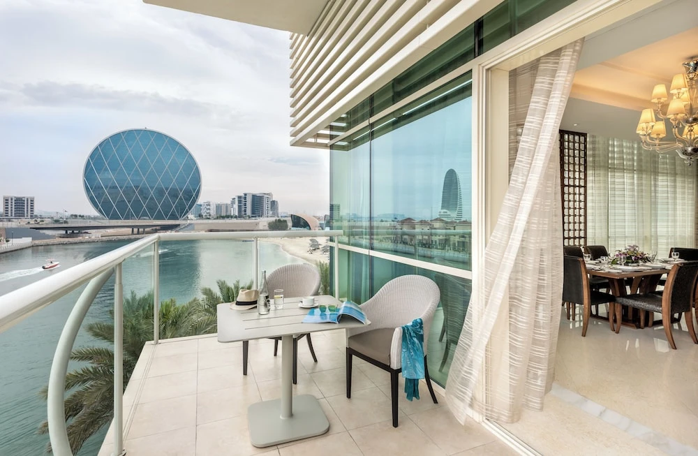 Balcony at Al Raha Beach Resort & Spa, Abu Dhabi, with city skyline view and glass-walled dining area