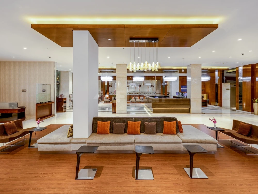 Lobby at Flora Al Barsha Hotel, Dubai, featuring wooden flooring and modern chandeliers
