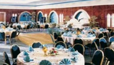 Banquet hall at Lou Lou'a Beach Resort, Sharjah, with arched alcoves and blue napkins on round tables