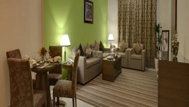 Lounge area at City Tower Hotel, Fujairah, with green accent wall and striped carpeting