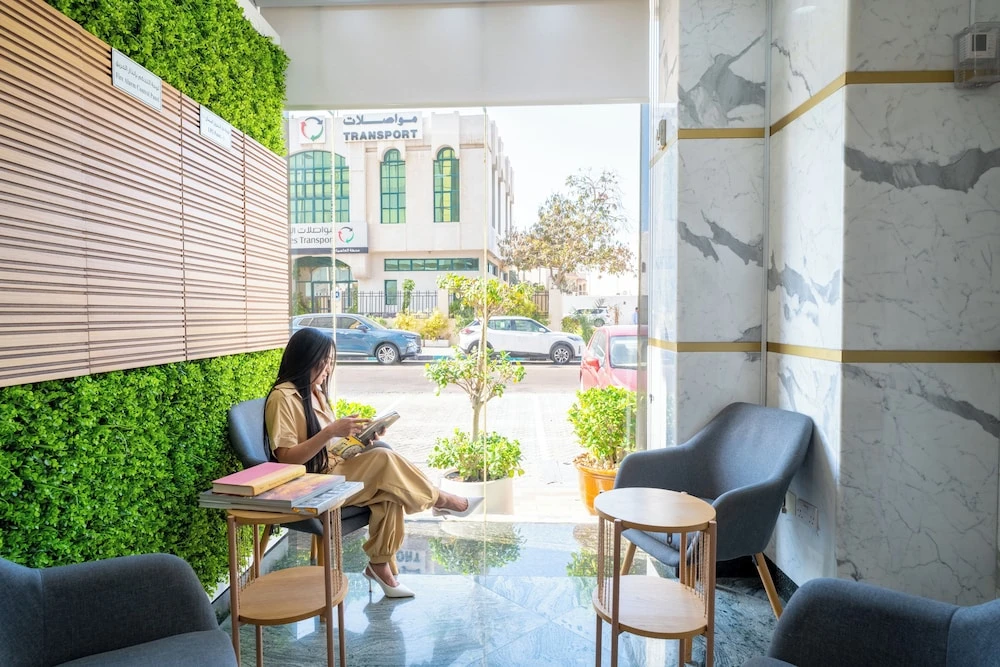 Lobby seating area at Al Nakheel Hotel Apartments, Abu Dhabi, with green living wall and marble pillars
