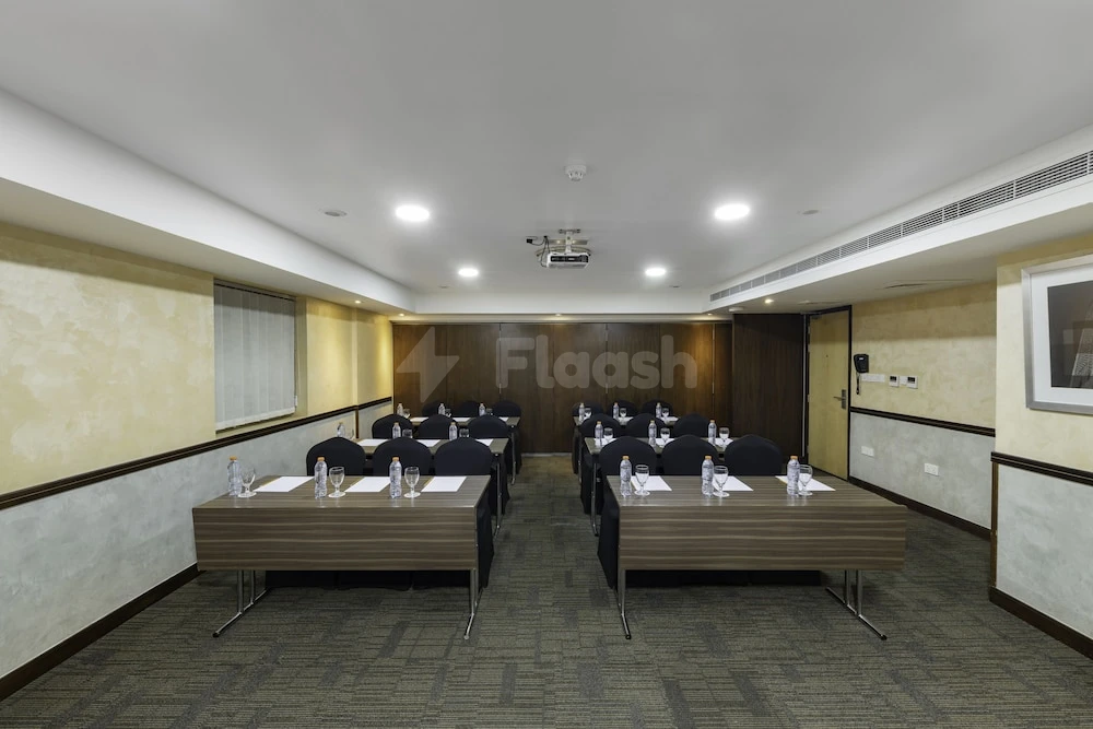 Conference room at Citymax Hotel Sharjah, arranged with tables and chairs under ceiling-mounted projector and lights