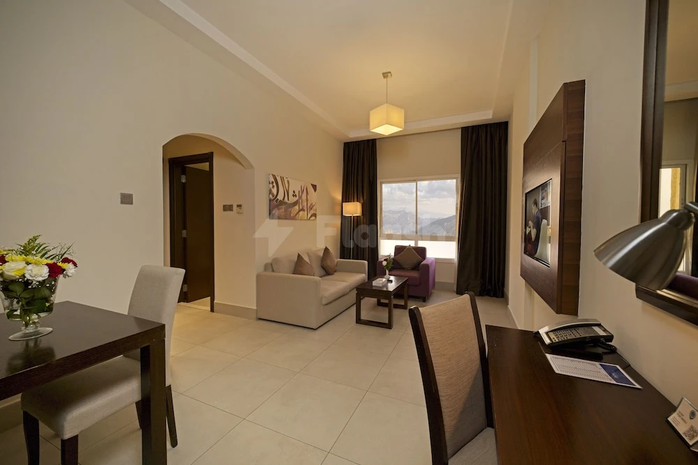 Lounge area at Action Hotel Ras Al Khaimah, Ras Al Khaimah, featuring a sofa by window with mountain