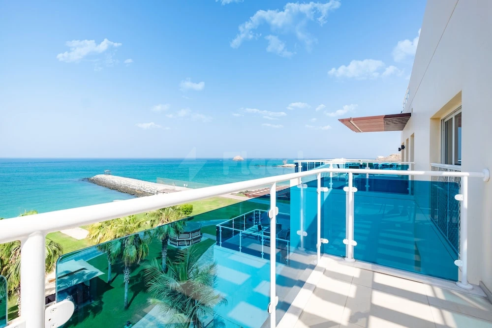 Balcony at Radisson Blu Resort Fujairah, Fujairah, overlooking turquoise sea and glass-bottom pool with white railings