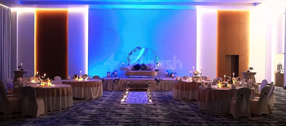 Banquet hall at Two Seasons Hotel & Apartments Dubai, Dubai, with candlelit tables and blue-lit stage arch