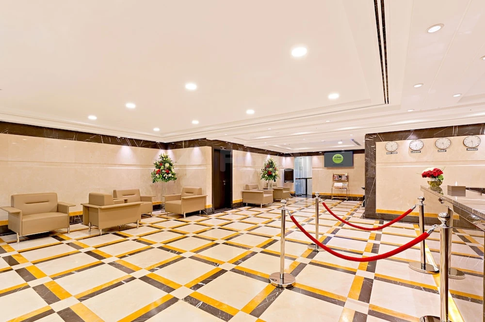 Lobby at TIME Moonstone Hotel Apartments, Fujairah, featuring checkered marble floors and red rope barriers
