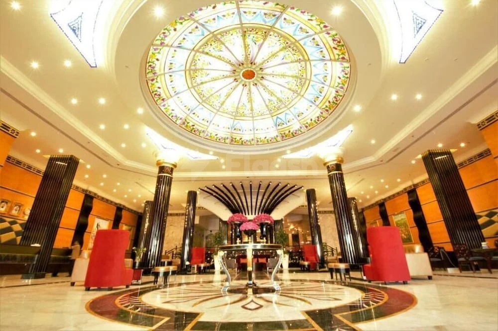 Grand lobby at Red Castle Hotel, Sharjah, featuring stained-glass dome ceiling and polished marble floors