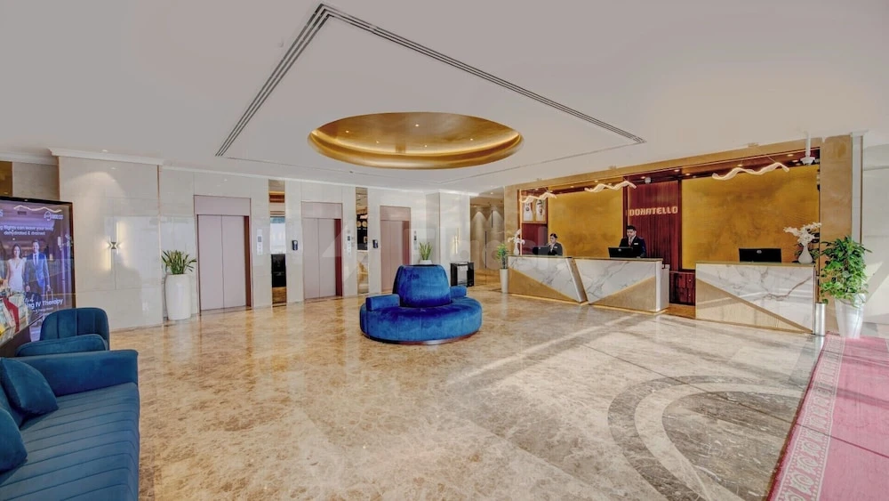 Lobby at Donatello Hotel Dubai, Dubai, featuring blue velvet seating and a gold-accented reception desk