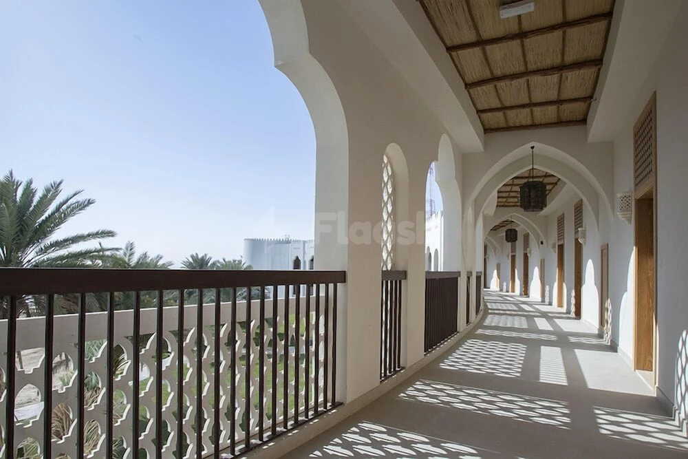 Arched colonnade at Liwa Hotel, Abu Dhabi, with latticed railings and geometric shadows