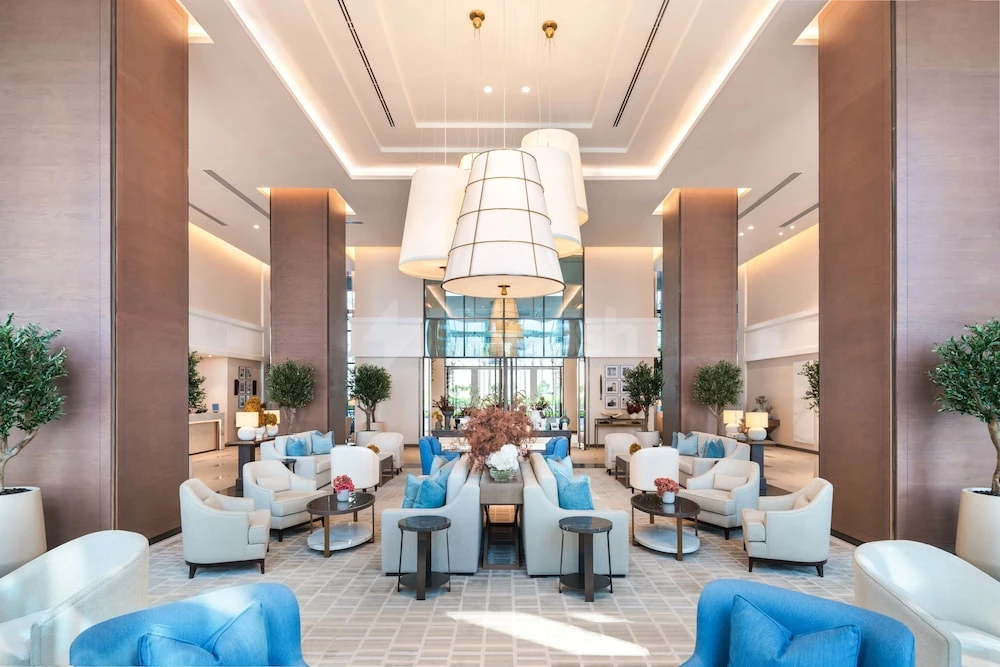 Lobby at Address Beach Resort Fujairah, Fujairah, with blue velvet armchairs and tiered pendant lights