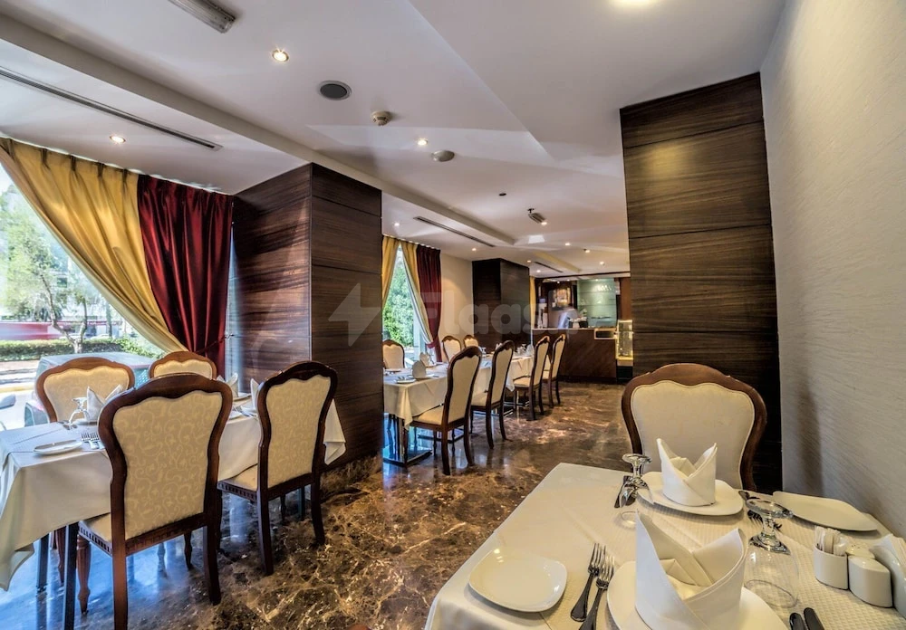 Dining room at Executive Suites - Abu Dhabi, Abu Dhabi, featuring marble floors and wooden paneling with red