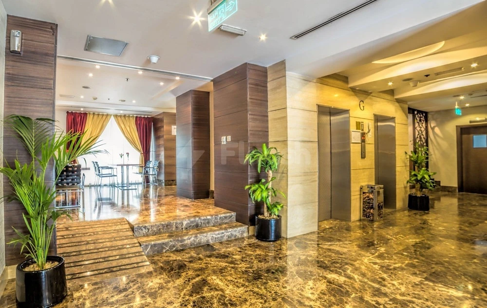 Lobby at Executive Suites - Abu Dhabi, Abu Dhabi, featuring marble flooring and potted plants near elevators