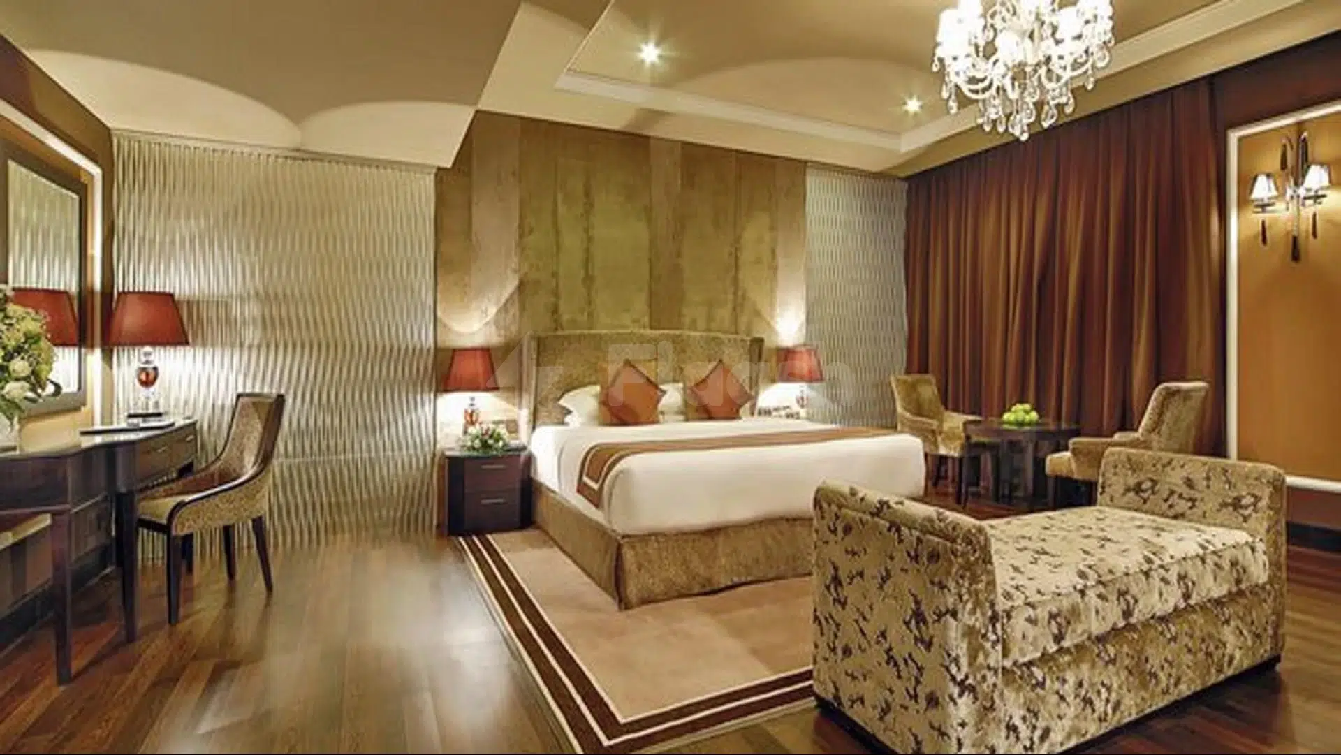 Luxury suite at Mangrove Hotel, Ras Al Khaimah, featuring a chandelier, patterned armchair, and warm wood tones
