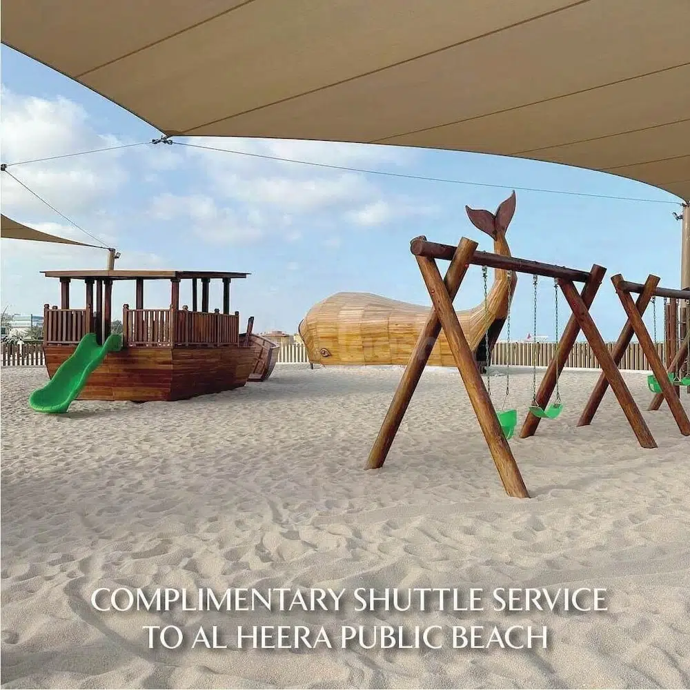 Playground at The Chedi Al Bait, Sharjah, featuring wooden ship playhouse and whale-tail swing set under canopy