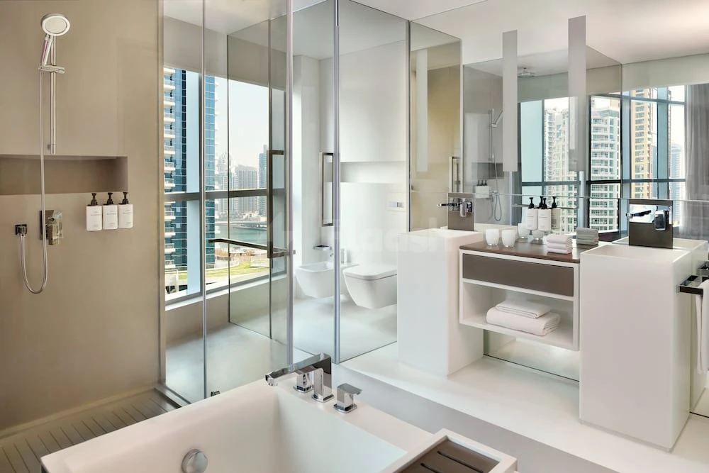 Bathroom at InterContinental Dubai Marina, Dubai, featuring glass shower enclosure and city skyline view through large windows