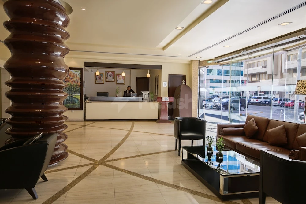 Lobby at Kingsgate Hotel Abu Dhabi by Millennium, Abu Dhabi, featuring a tiered sculpture and glass-walled street$view