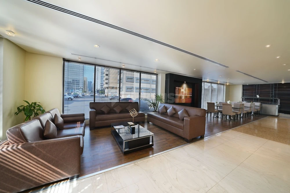 Lounge area at Kingsgate Hotel Abu Dhabi By Millennium, Abu Dhabi, featuring leather sofas and large city-view windows