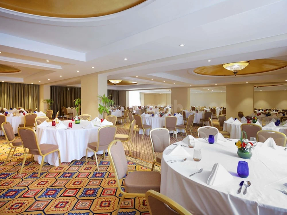 Banquet hall at Pullman Resort Al Marjan Island, Ras Al-Khaimah, with round tables set for dining and colorful