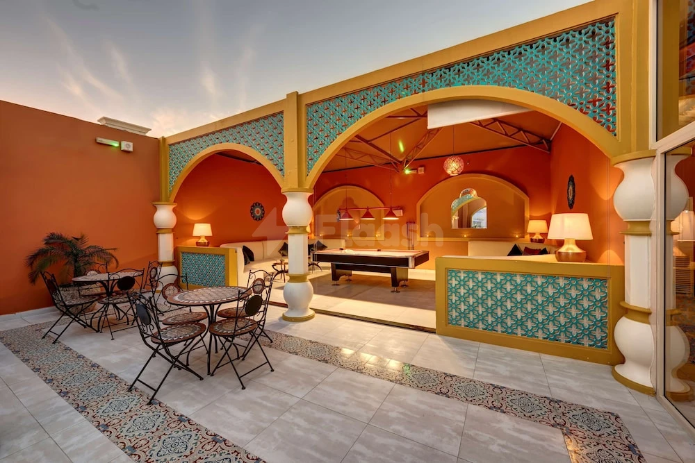 Terrace lounge at Radisson Blu Hotel Ajman, Ajman, featuring arched alcoves and turquoise patterned screens
