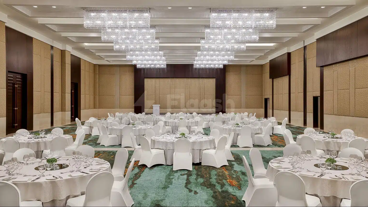 Banquet hall at Anantara Downtown Dubai Hotel, Dubai, with crystal chandeliers and white draped tables on patterned carpet