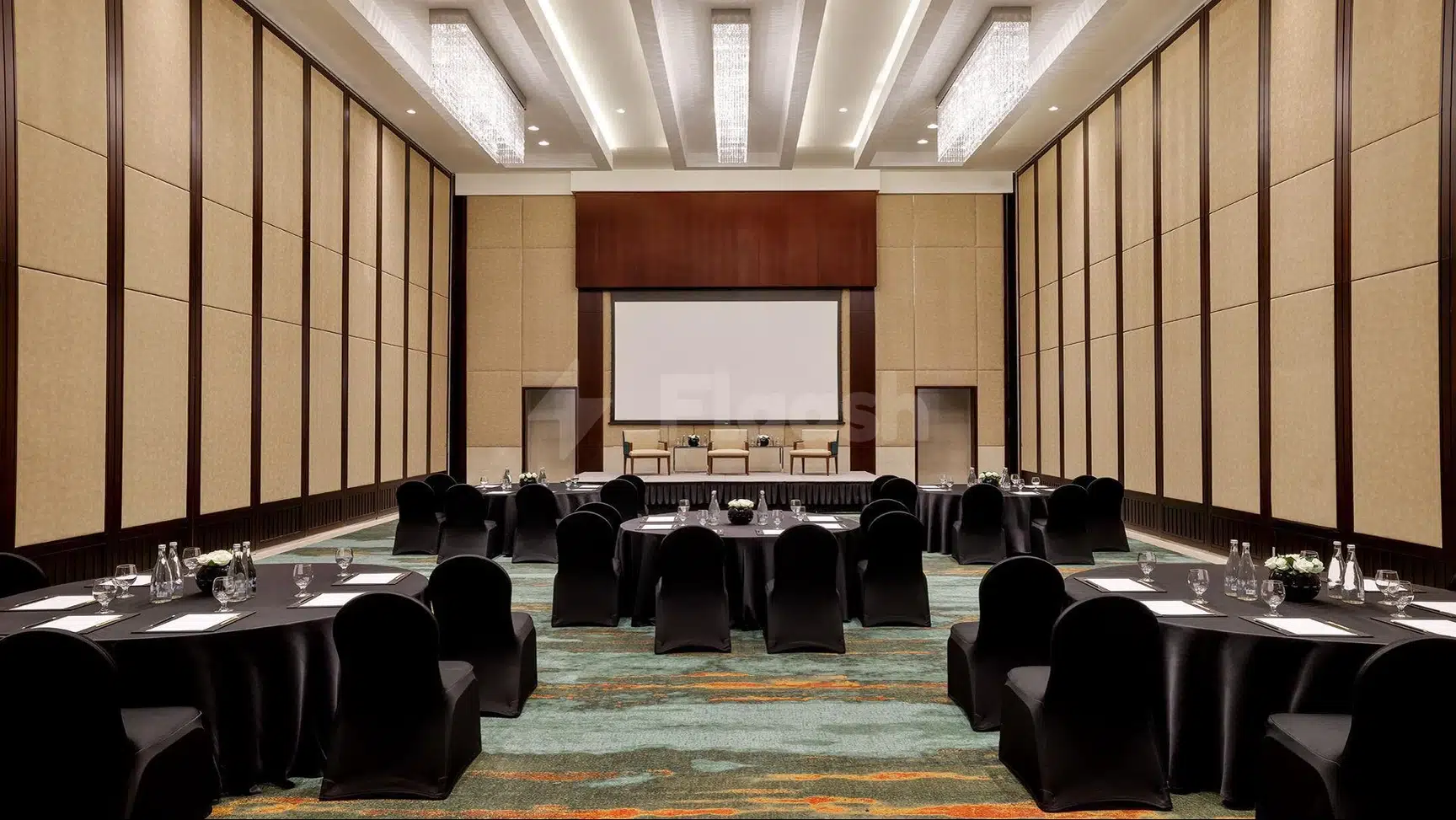 Conference room at Anantara Downtown Dubai Hotel, Dubai, with tables set for meeting and large screen on stage