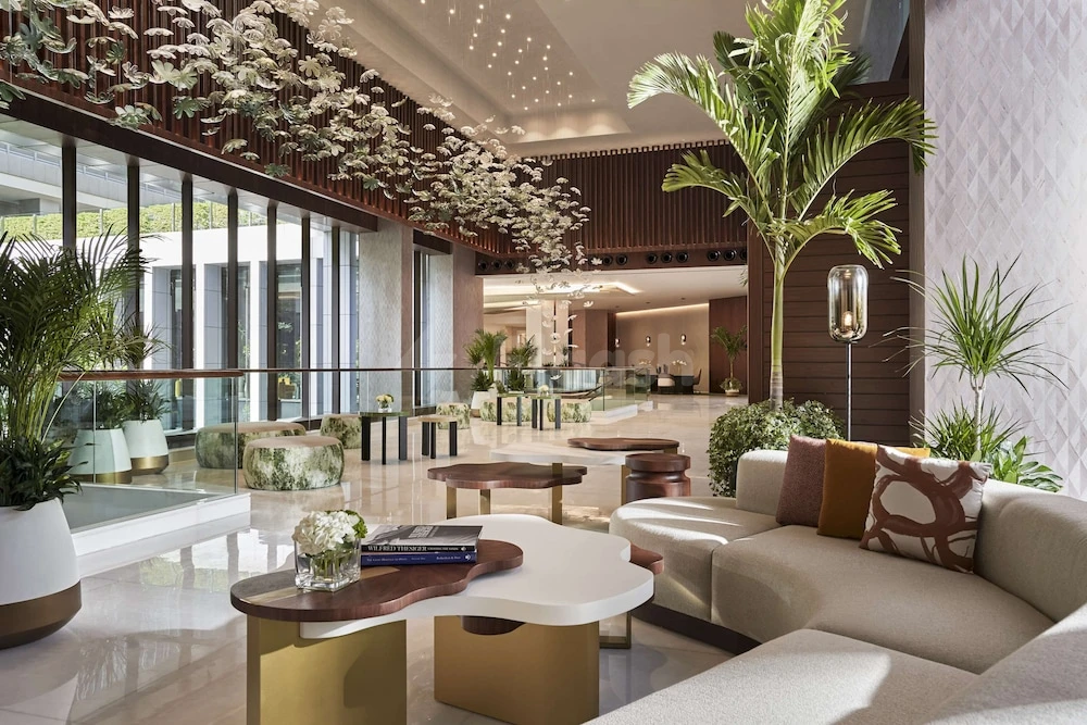 Lobby at Anantara Downtown Dubai Hotel, Dubai, with white floral ceiling installation and tall indoor palms