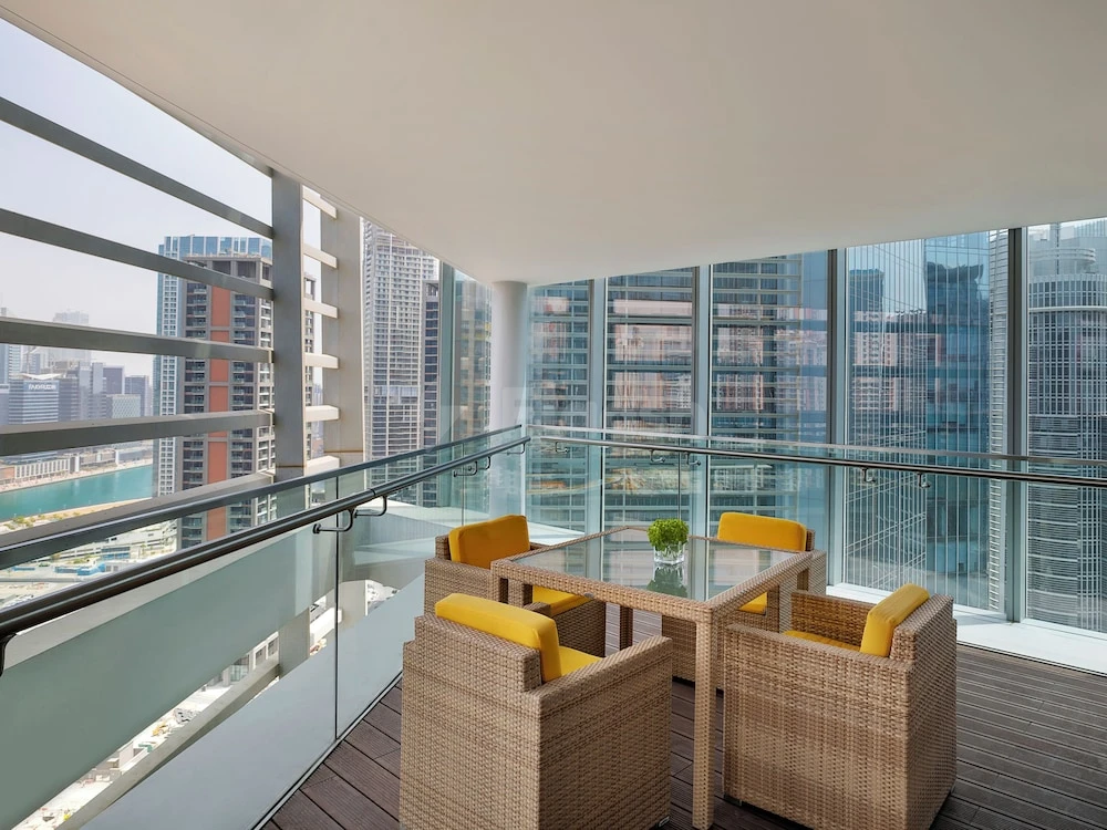 Rooftop terrace at Anantara Downtown Dubai Hotel, Dubai, with wicker seating and glass railings overlooking city skyline