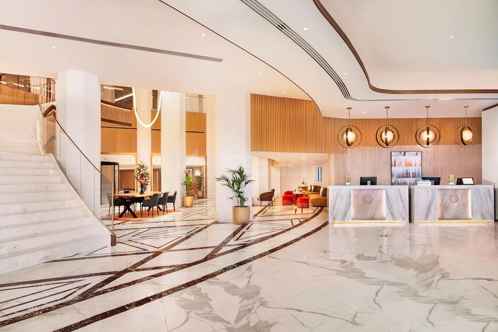 Marble lobby at Sheraton Abu Dhabi Hotel & Resort, Abu Dhabi, with curved staircase and modern reception desks