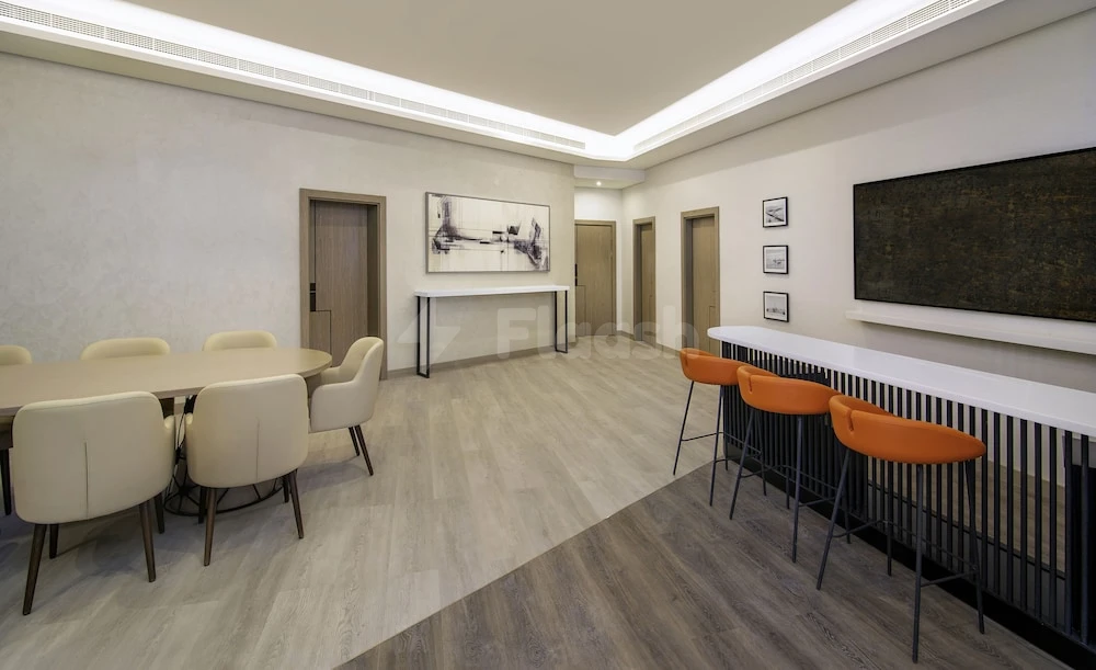 Modern lounge area at Sheraton Abu Dhabi Hotel & Resort, Abu Dhabi, with orange bar stools and a long