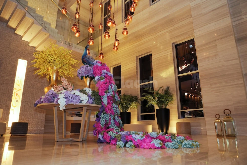 Lobby at DoubleTree by Hilton Fujairah City, Fujaira, with peacock sculpture and cascading floral arrangement under hanging copper