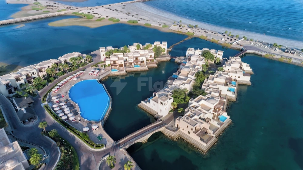 Aerial view of The Cove Rotana Resort, Ras Al-Khaimah, featuring a central lagoon, waterfront villas, and a large