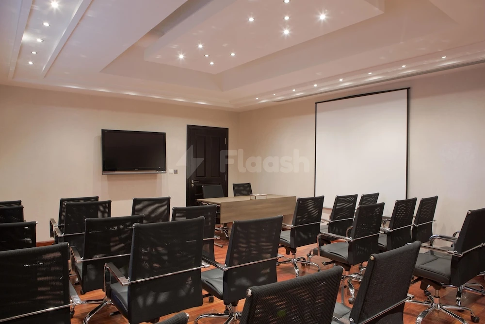 Conference room at The Cove Rotana Resort, Ras Al-Khaimah, with tiered seating and large projection screen