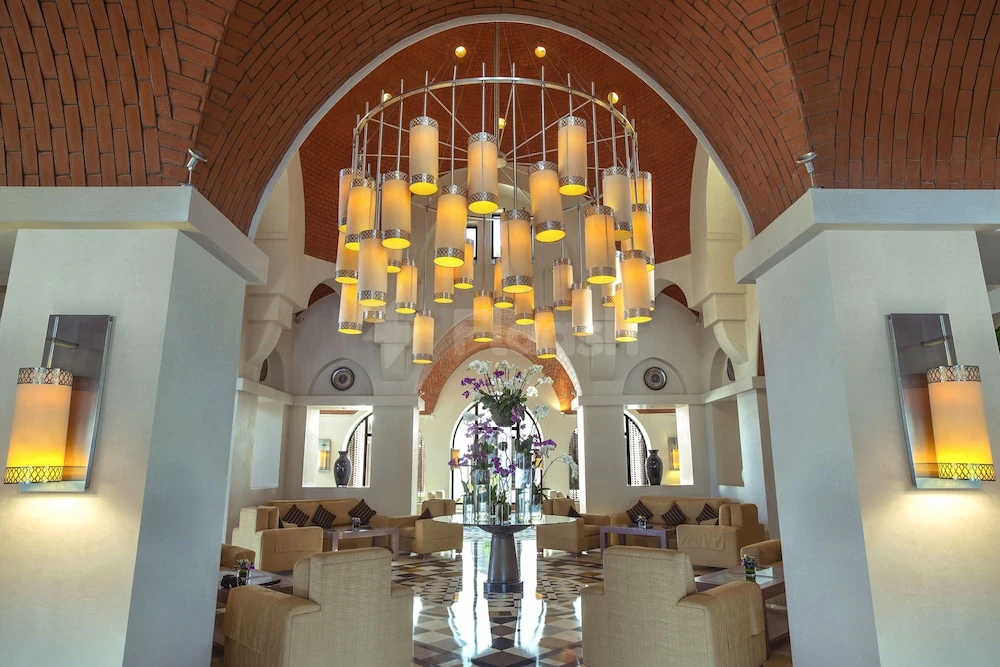 Lobby at The Cove Rotana Resort, Ras Al-Khaimah, with arched brick ceiling and cascading chandelier