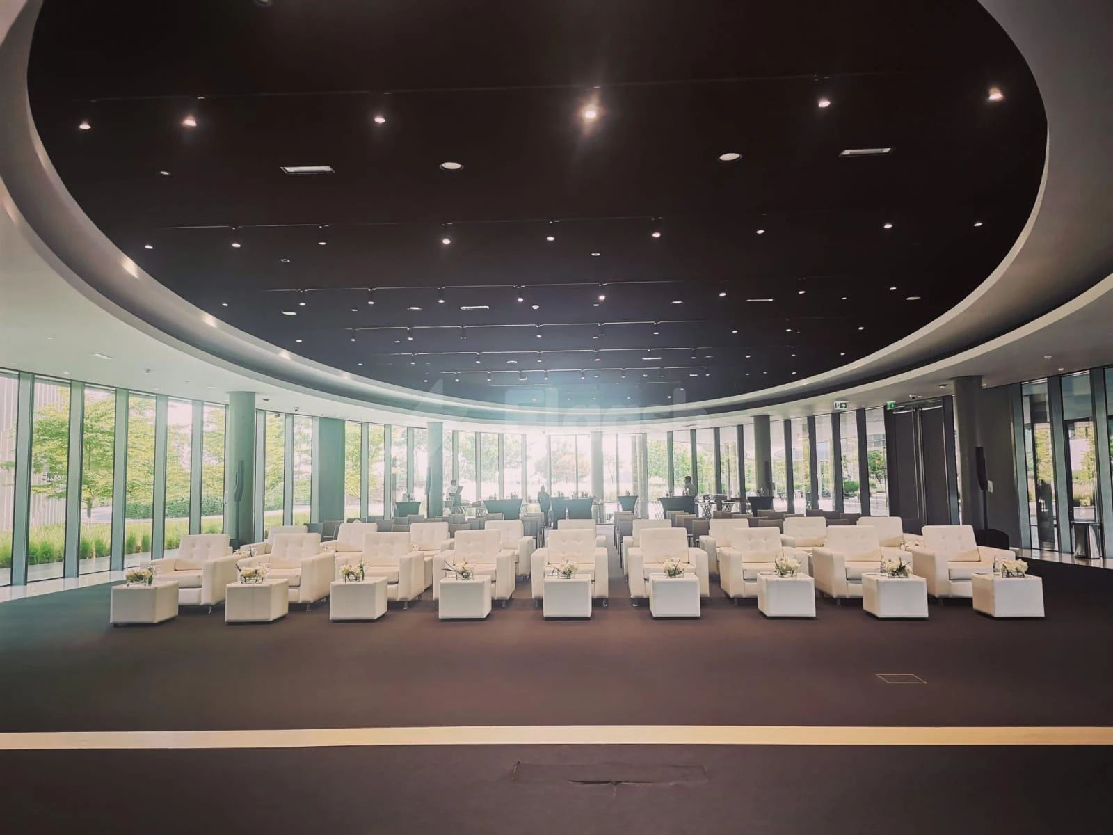 Circular lounge at YourSpace Aljada, Sharjah, with white seating and floor-to-ceiling glass walls