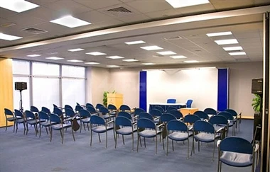 Conference hall at Expo Centre Sharjah, Sharjah, with rows of blue chairs under recessed ceiling lights