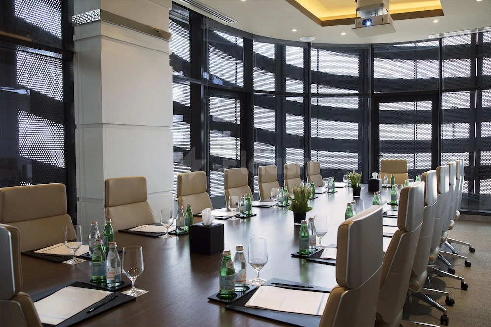 Boardroom at Pearl Rotana Capital Centre, Abu Dhabi, with curved glass walls and modern lighting fixtures