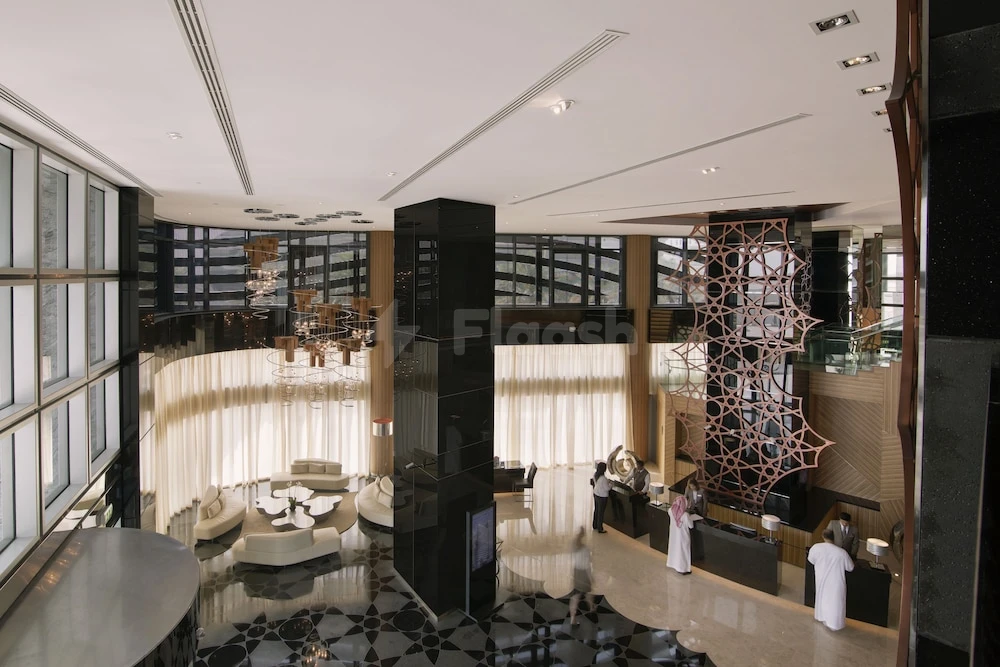Grand lobby at Pearl Rotana Capital Centre, Abu Dhabi, featuring geometric black marble flooring and a large copper