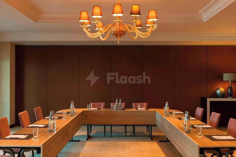 Boardroom at Ajman Saray, a Luxury Collection Resort, Ajman, with brass chandelier and U-shaped walnut table