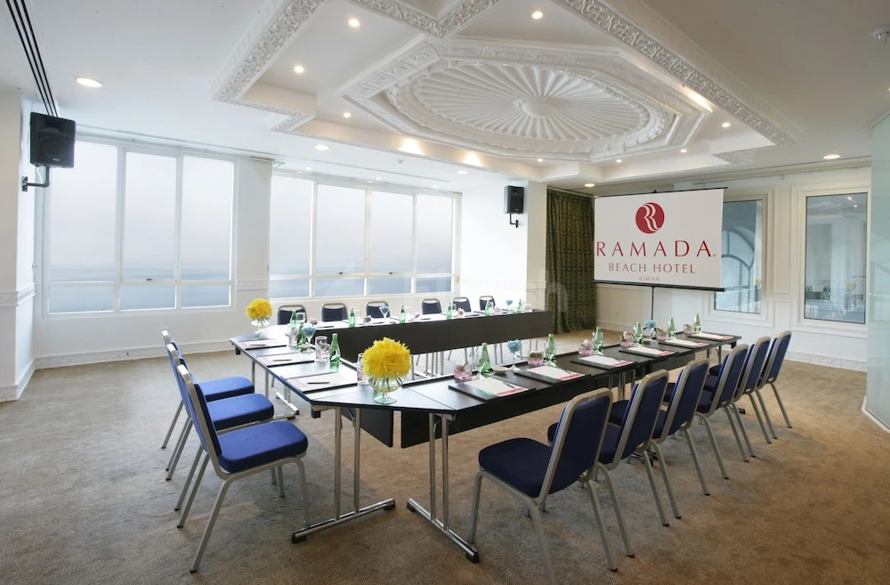Conference room at Ramada by Wyndham Beach Hotel Ajman, with ocean view through large windows and branded screen