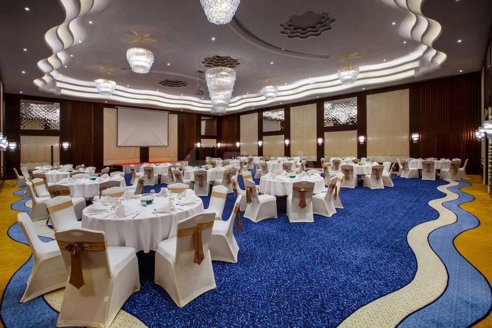 Banquet hall at Danat Jebel Dhanna Resort, Abu Dhabi, featuring wave-patterned carpet and crystal chandeliers